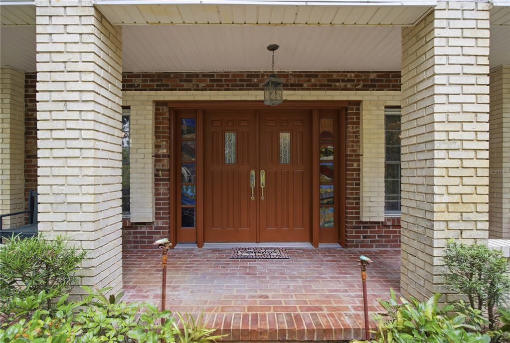 A brick porch features a double front door with stained glass sidelights and brick columns — 2271 KEYSTONE ROAD, TARPON SPRINGS, FL
