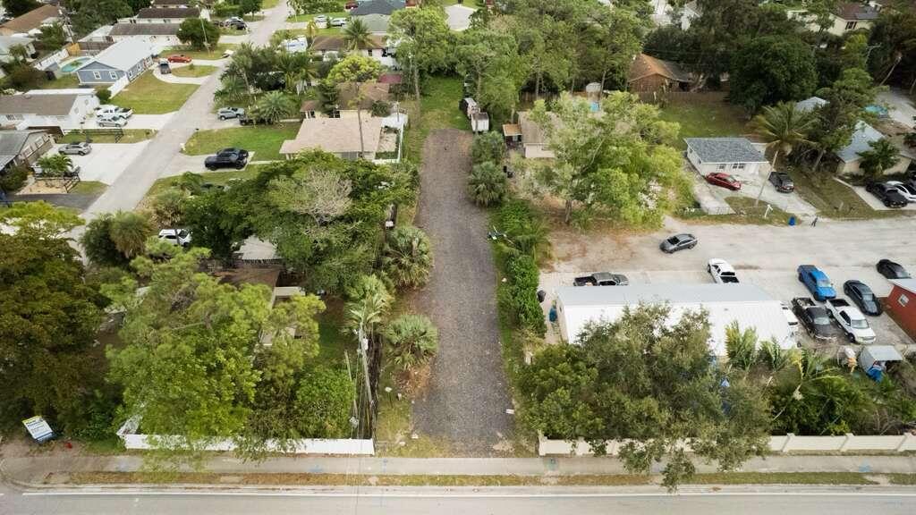 An aerial view shows a long, narrow gravel driveway situated between two residential properties — 3630 S Haverhill Road, FL 33463, FL