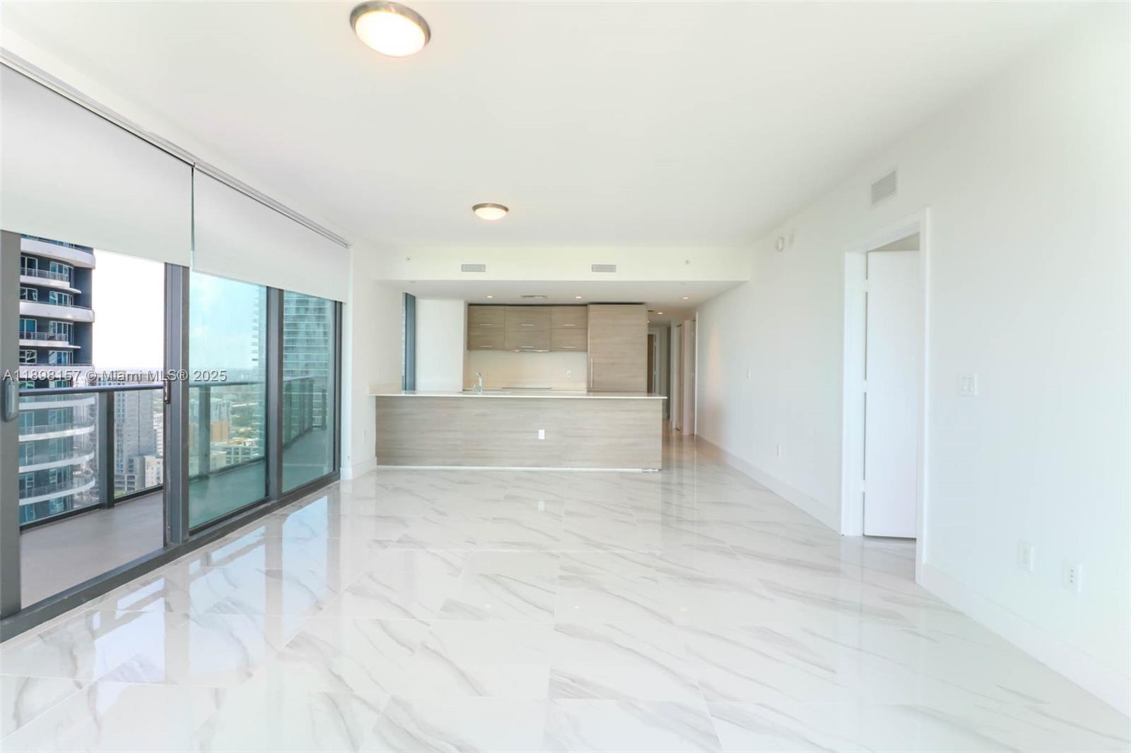 An open-concept living area features white marble floors, a modern kitchen, and a balcony view — 1300 S miami # 2706, Miami FL 33130, MIAMI, FL