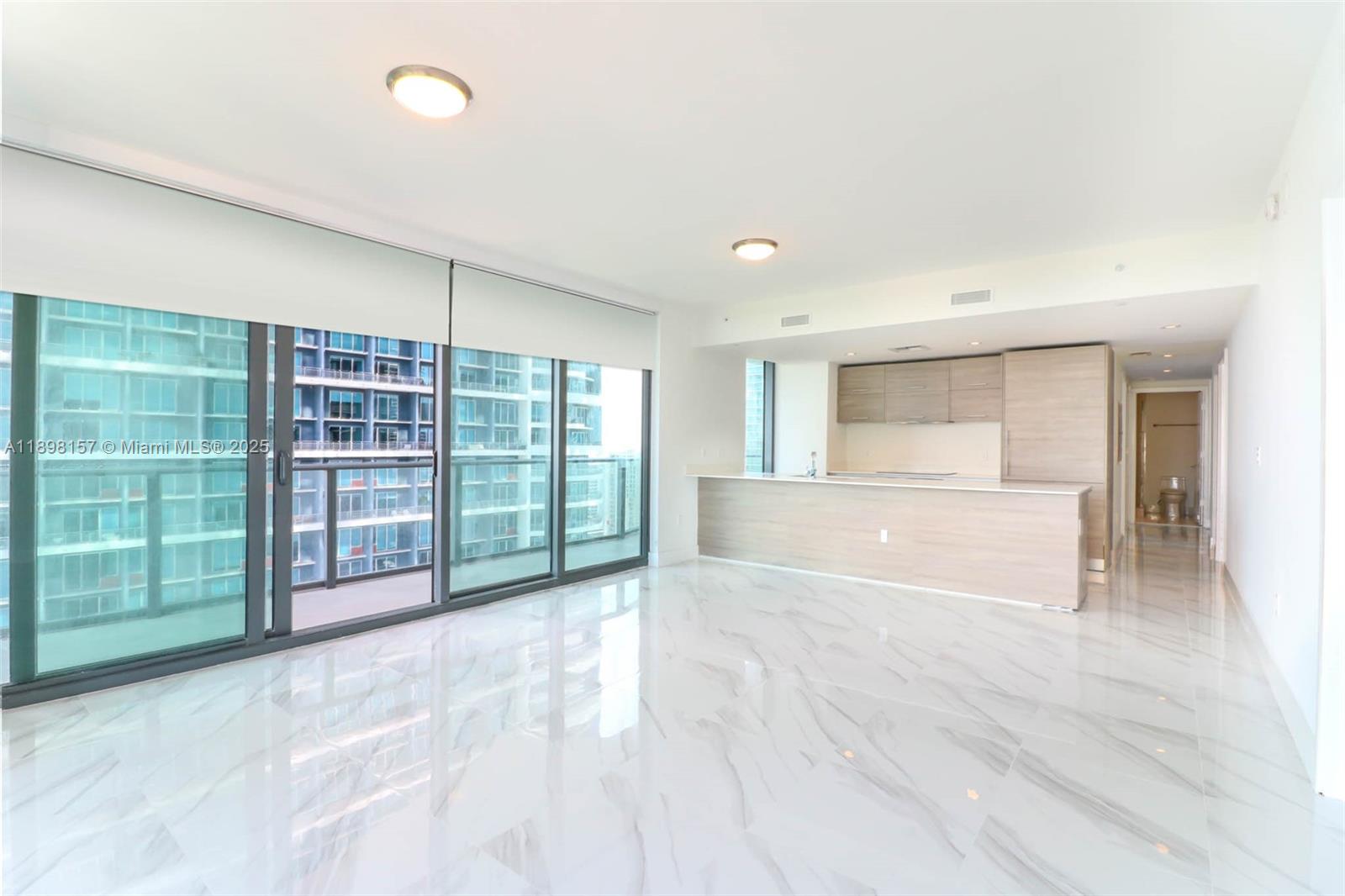 An open-concept living area features white marble floors, a kitchen island, and floor-to-ceiling windows — 1300 S miami # 2706, Miami FL 33130, MIAMI, FL