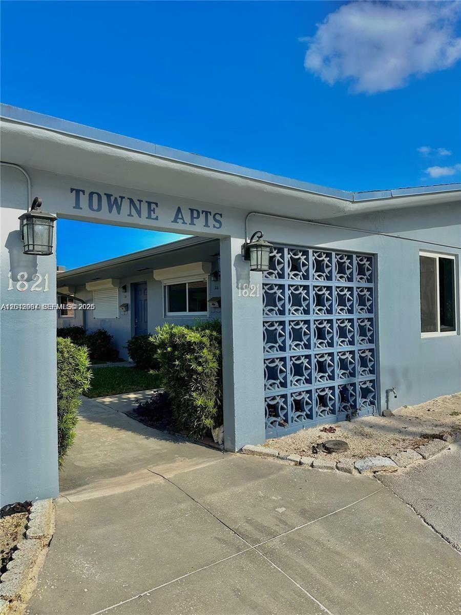 The exterior of a blue apartment building features a covered walkway and decorative breeze blocks — 1821 N 17th Ct # 26, Hollywood FL 33020, HOLLYWOOD, FL