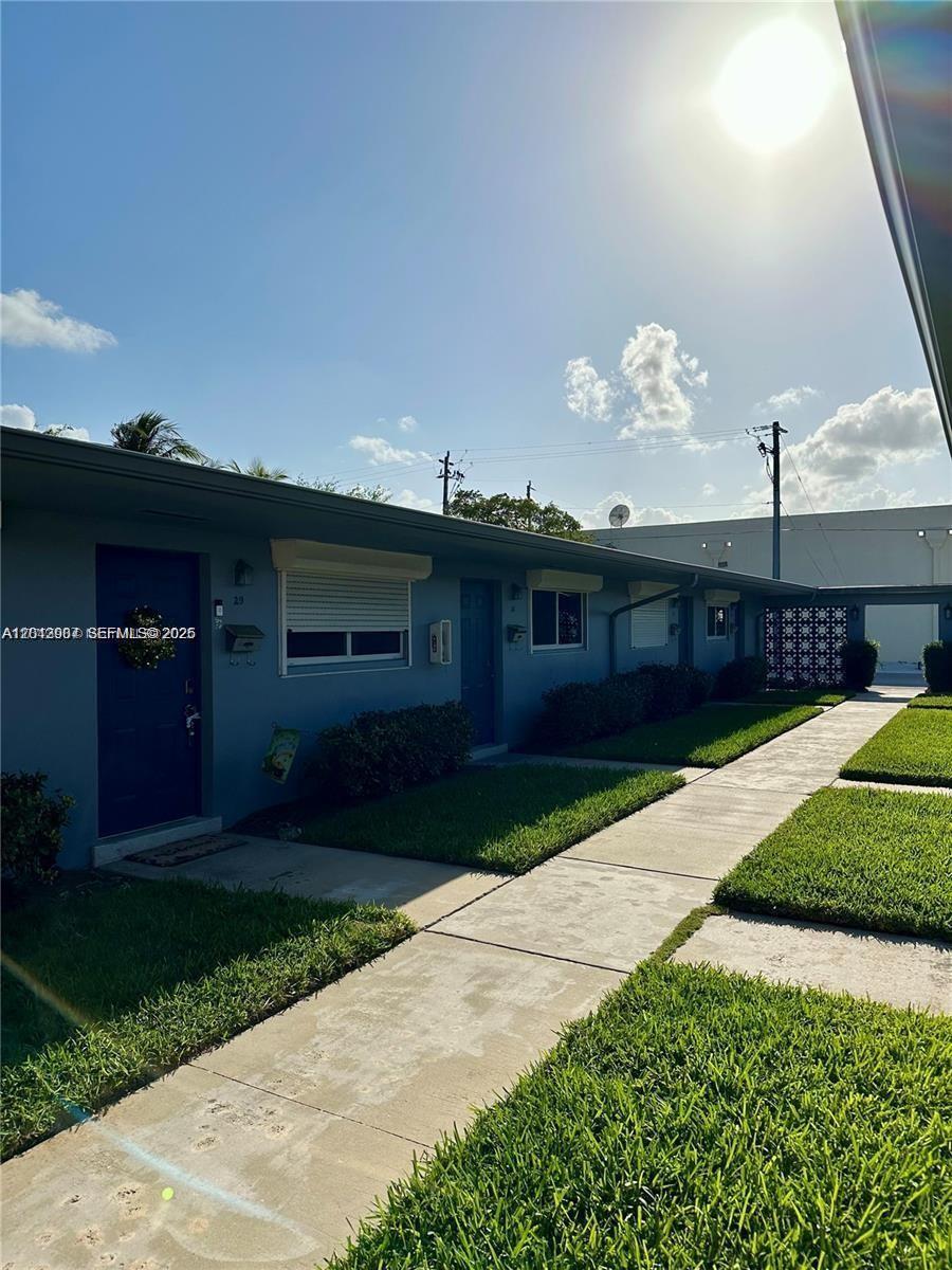 A single-story blue apartment building with a sidewalk and lawn in front — 1821 N 17th Ct # 26, Hollywood FL 33020, HOLLYWOOD, FL