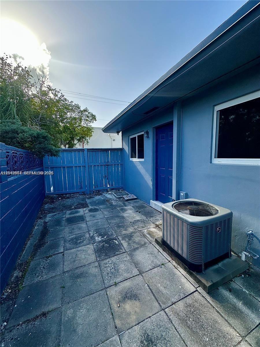A blue-painted exterior wall features a door, a window, and an air conditioning unit — 1821 N 17th Ct # 26, Hollywood FL 33020, HOLLYWOOD, FL