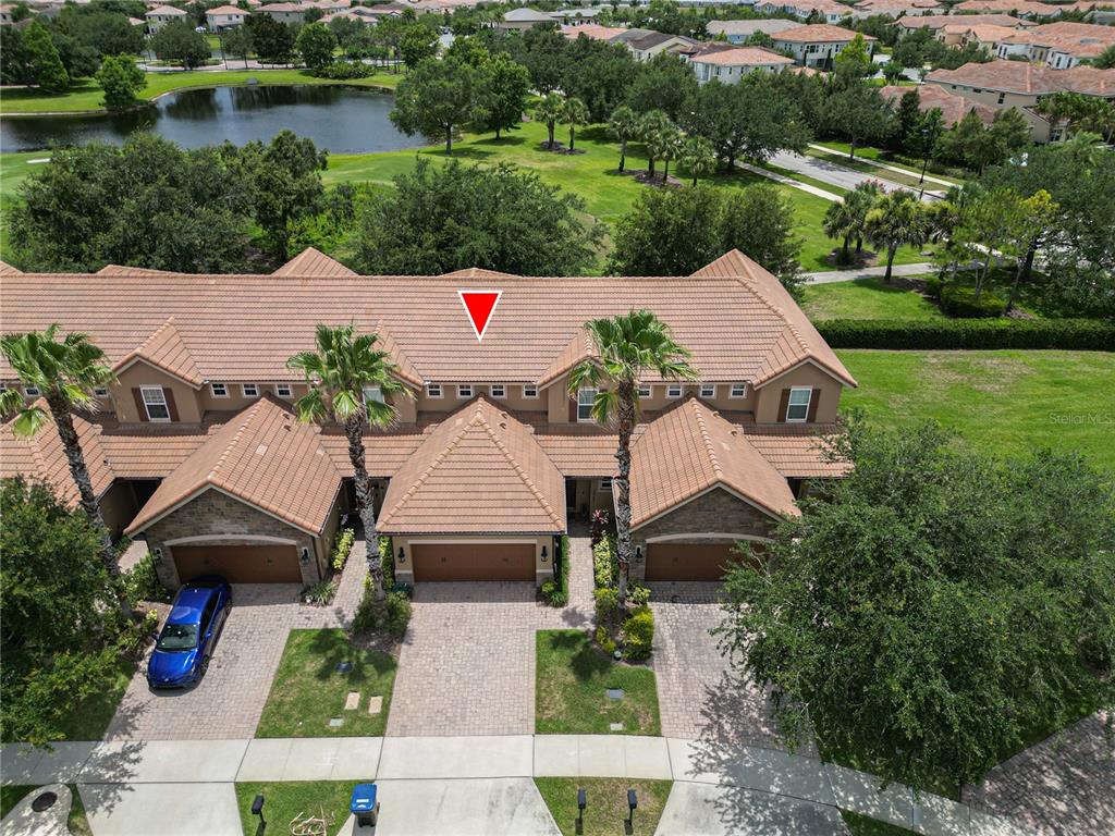 An aerial view shows a row of townhouses with tiled roofs and attached garages — 10751 BELFRY CIRCLE, ORLANDO, FL