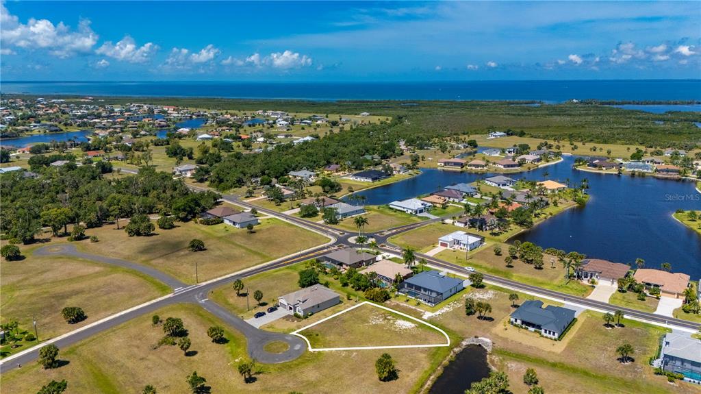 An aerial view shows a vacant residential lot outlined in white within a suburban neighborhood — 16429 AYSON WAY, PUNTA GORDA, FL