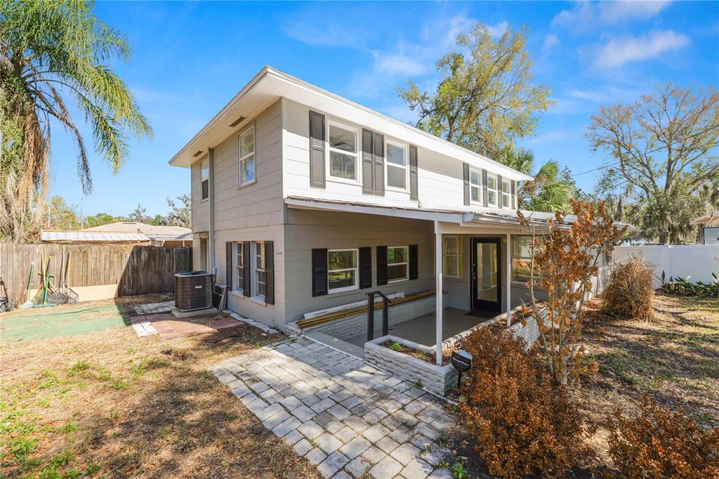 A two-story house with gray siding, a covered porch, and a stone paver walkway — 961 DREXEL AVENUE NE, WINTER HAVEN, FL