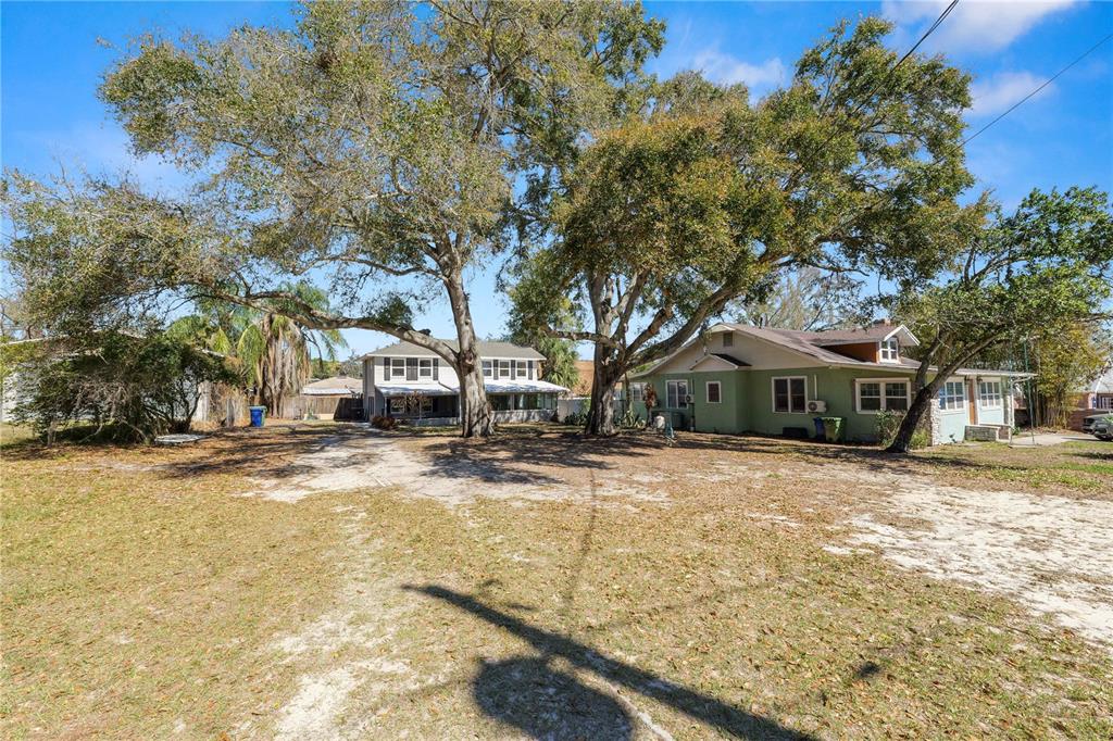 Two houses sit on a large, sandy lot shaded by several large, mature oak trees — 961 DREXEL AVENUE NE, WINTER HAVEN, FL