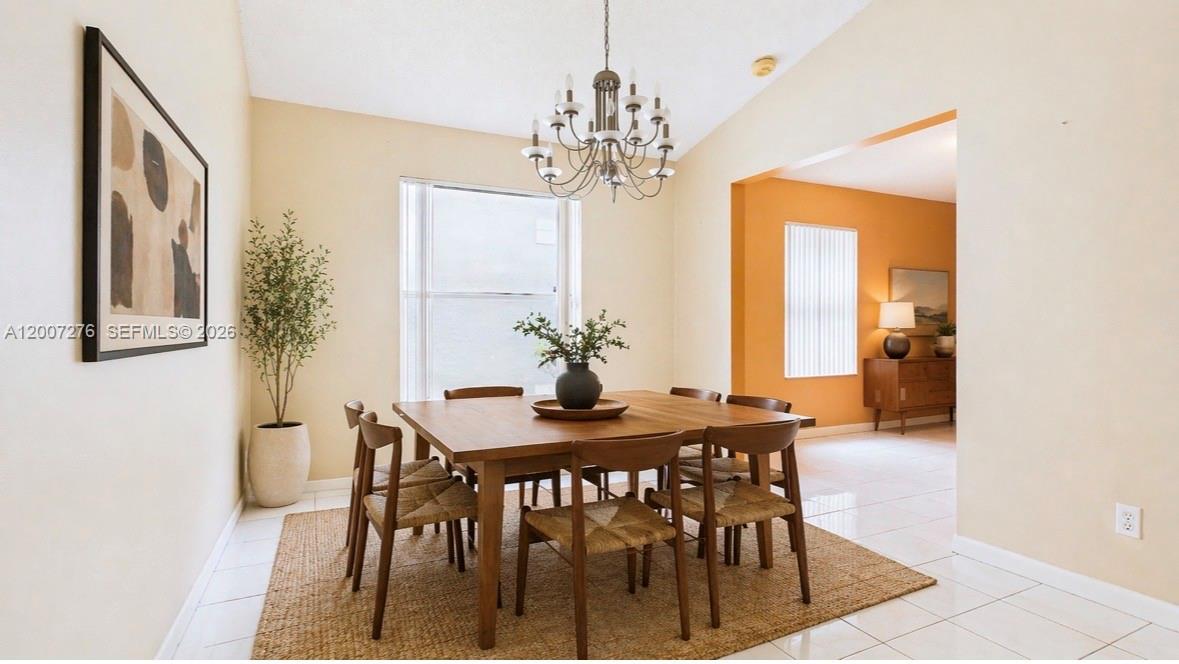 A dining room features a square wooden table, six chairs, and a chandelier on tile — 17626 SW 20th St, Miramar FL 33029, MIRAMAR, FL