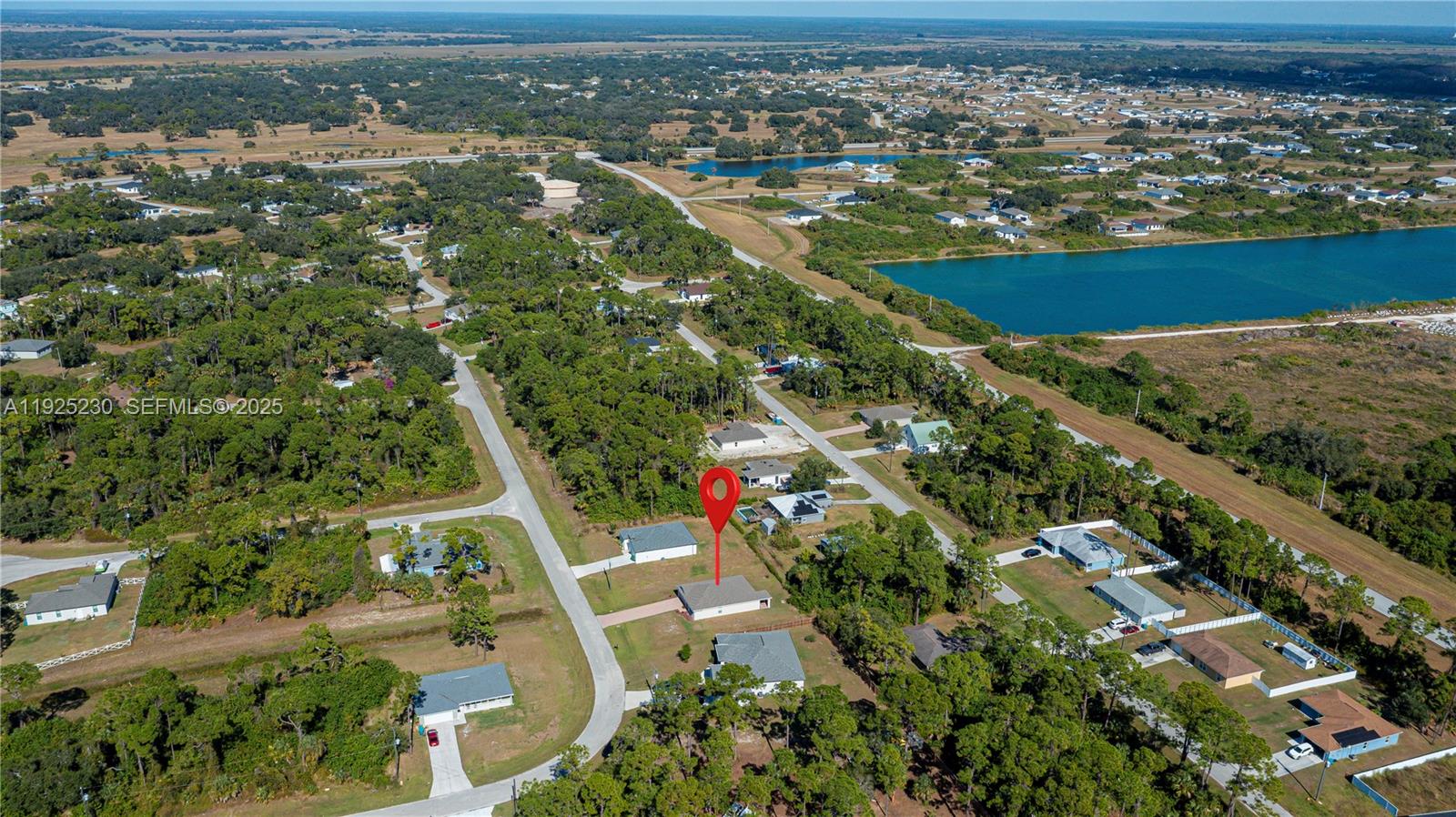 An aerial view shows a single-story house with a red location pin in a wooded area — 6058 S Moss Circle, La Belle FL 33935, LA BELLE, FL