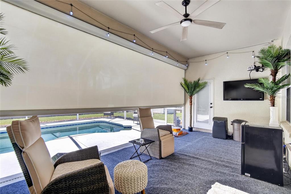 A covered patio features a pool view, outdoor furniture, a ceiling fan, and string lights — 11937 TIMBERHILL DRIVE, RIVERVIEW, FL