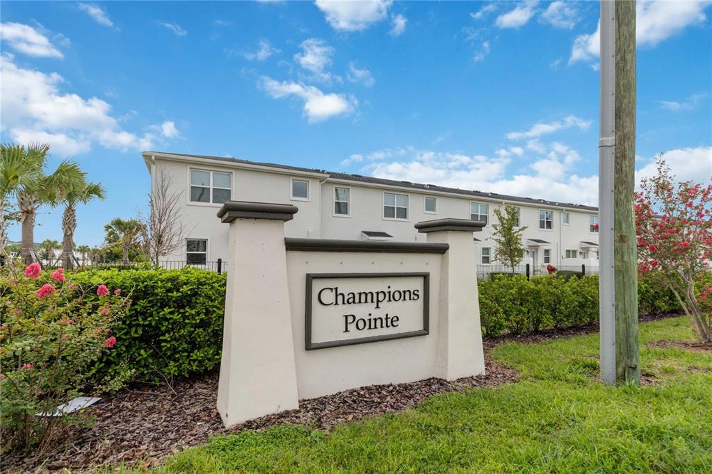 A sign for Champions Pointe stands in front of a multi-story residential building — 299 NINE IRON DRIVE, DAVENPORT, FL