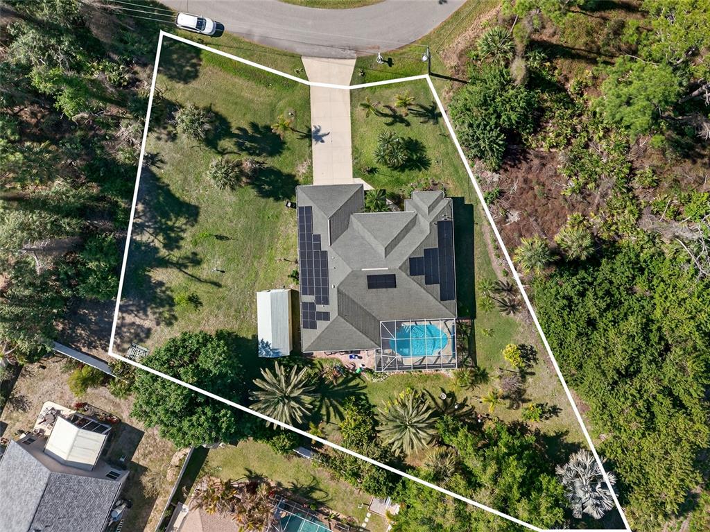An aerial view shows a house with a pool and solar panels on a large lot — 7270 PARAGON ROAD, NORTH PORT, FL