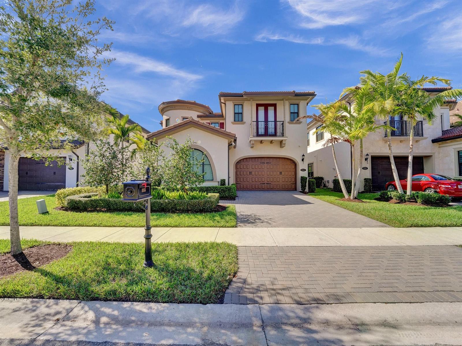 A two-story stucco house with a tiled roof, arched garage door, and a paved driveway — 9345 Carrington Avenue, Parkland FL 33076, PARKLAND, FL