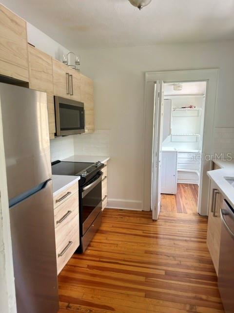 A kitchen with light wood cabinets, stainless steel appliances, and hardwood floors — 1416 LOCUST STREET NE, ST PETERSBURG, FL