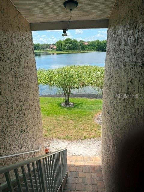 A view from a covered stairway looking out toward a lake with lily pads — 145 N PEARL LAKE CAUSEWAY UNIT 210, ALTAMONTE SPRINGS, FL