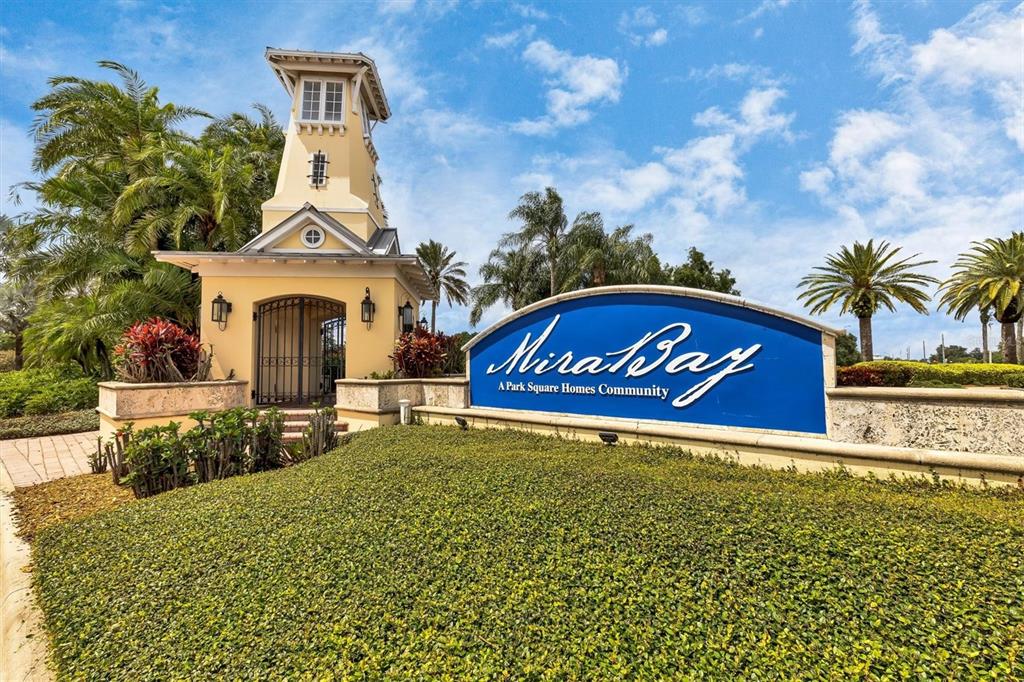 The entrance sign for the MiraBay community features a yellow tower and blue signage — 724 WINTERSIDE DRIVE, APOLLO BEACH, FL