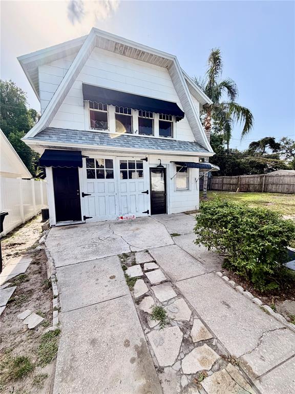 A two-story white building features a gambrel roof, black awnings, and a concrete driveway — 1249 SEDEEVA CIRCLE S, CLEARWATER, FL