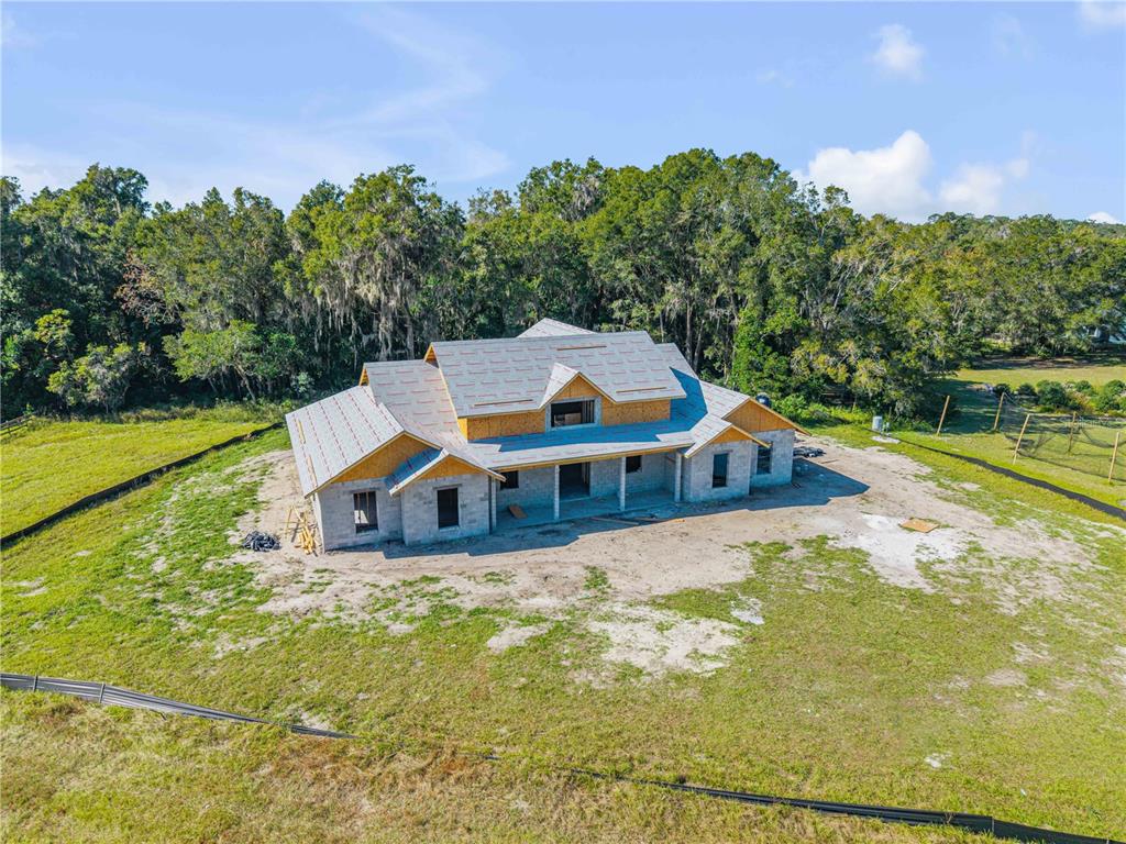 A white house with a metal roof sits on a large, grassy lot — 1624 GREENS DAIRY ROAD, DELAND, FL