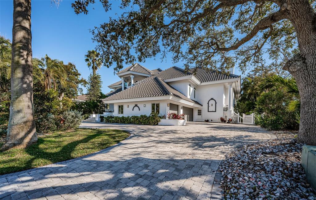 A large white two-story house with a tiled roof and a paved circular driveway — 5212 62ND AVENUE S, ST PETERSBURG, FL