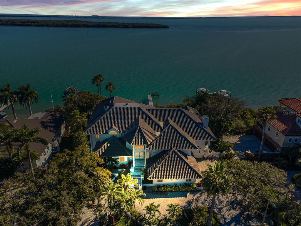 An aerial view of a large waterfront house with a tiled roof and palm trees — 5212 62ND AVENUE S, ST PETERSBURG, FL