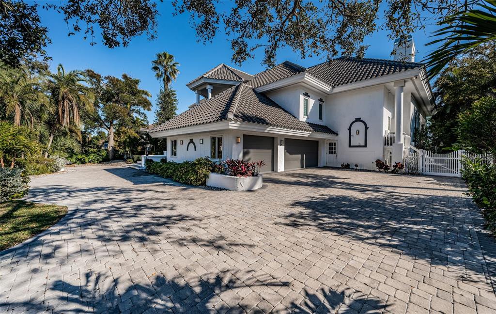 A two-story white house with a tiled roof and a large paved driveway — 5212 62ND AVENUE S, ST PETERSBURG, FL
