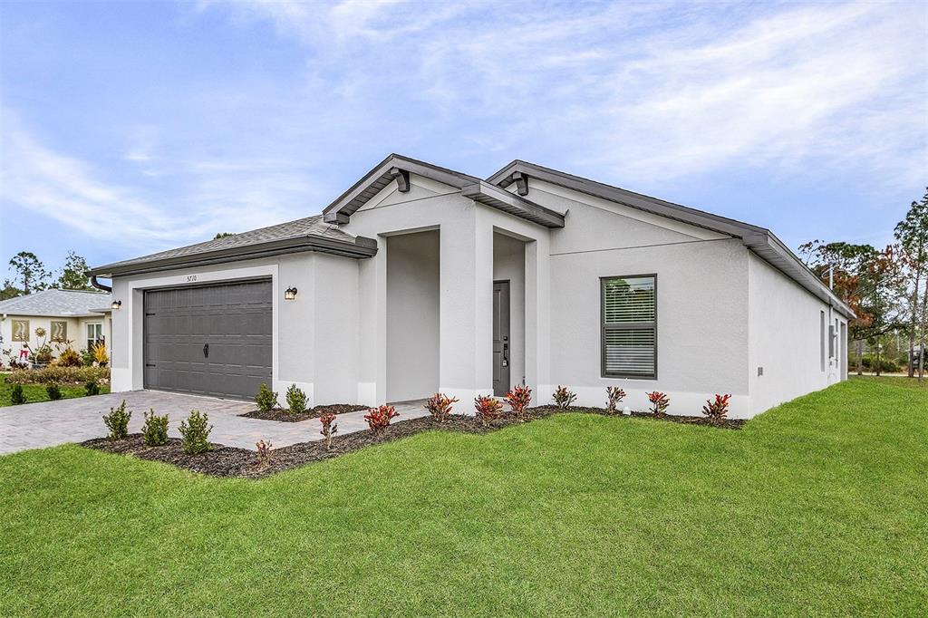 A single-story house with a gray garage, white stucco exterior, and a paved driveway — 4562 TAHITI STREET, NORTH PORT, FL