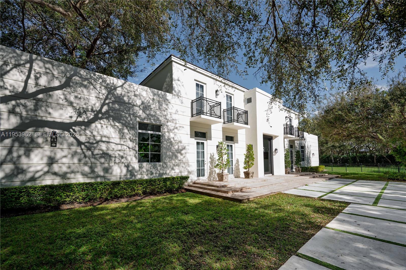 A two-story white modern house features balconies, large windows, and a paved driveway — 6355 SW 114th St, Pinecrest FL 33156, PINECREST, FL