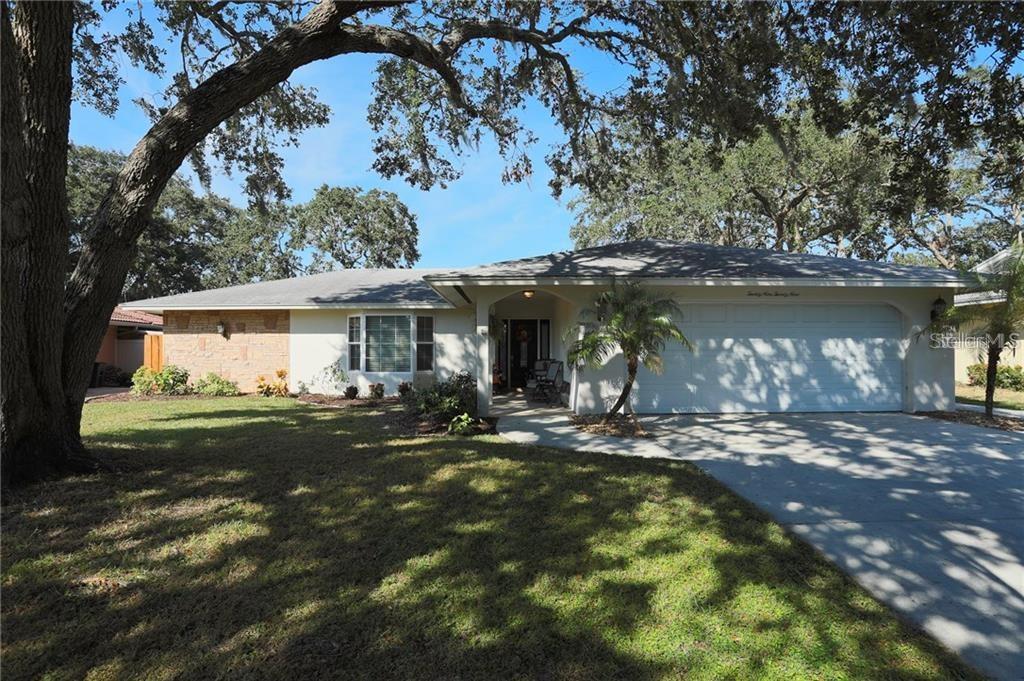 A single-story house with a brick facade, a two-car garage, and large oak trees — 2929 MAYFLOWER STREET, SARASOTA, FL