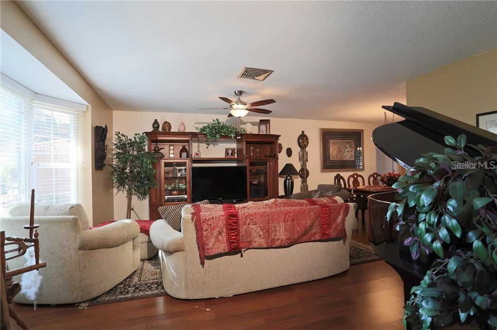 A living room features a sofa, an entertainment center, a ceiling fan, and a grand piano — 2929 MAYFLOWER STREET, SARASOTA, FL