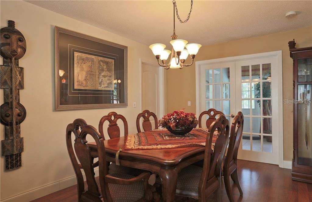 A dining room with a wooden table, chairs, a chandelier, and wall art — 2929 MAYFLOWER STREET, SARASOTA, FL