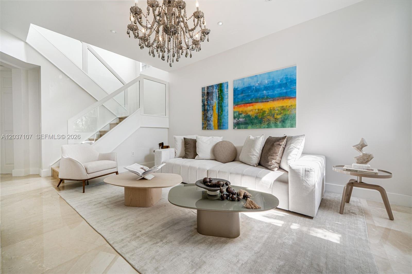 A modern living room features a white sofa, two coffee tables, and a grand chandelier — 21156 NE 33rd Ave, Aventura FL 33180, AVENTURA, FL