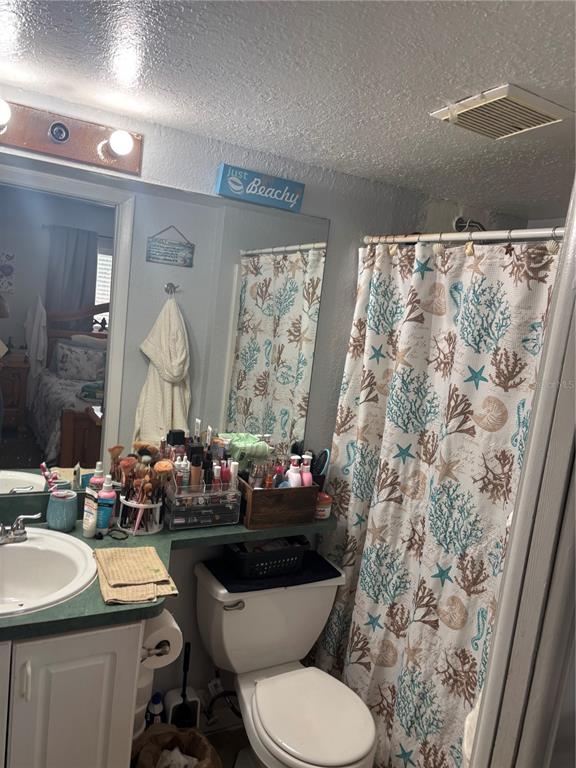 A bathroom features a green vanity, a toilet, and a shower curtain with coral patterns — 732 MCDOUGALL COURT UNIT 732, ORLANDO, FL