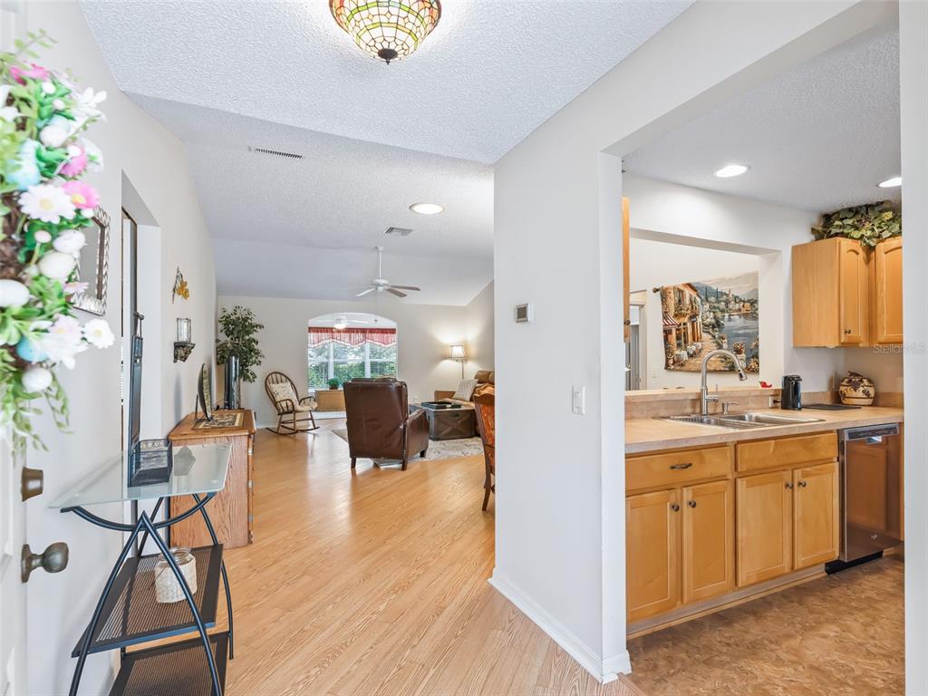 A view from an entryway looking into a living room and an adjacent kitchen — 17325 SE 91ST LEE AVENUE, THE VILLAGES, FL