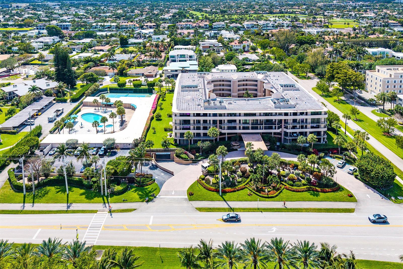 An aerial view shows a multi-story apartment building with a central courtyard, pool, and tennis courts — 1401 S Ocean Boulevard # 1050, Boca Raton FL 33432, BOCA RATON, FL