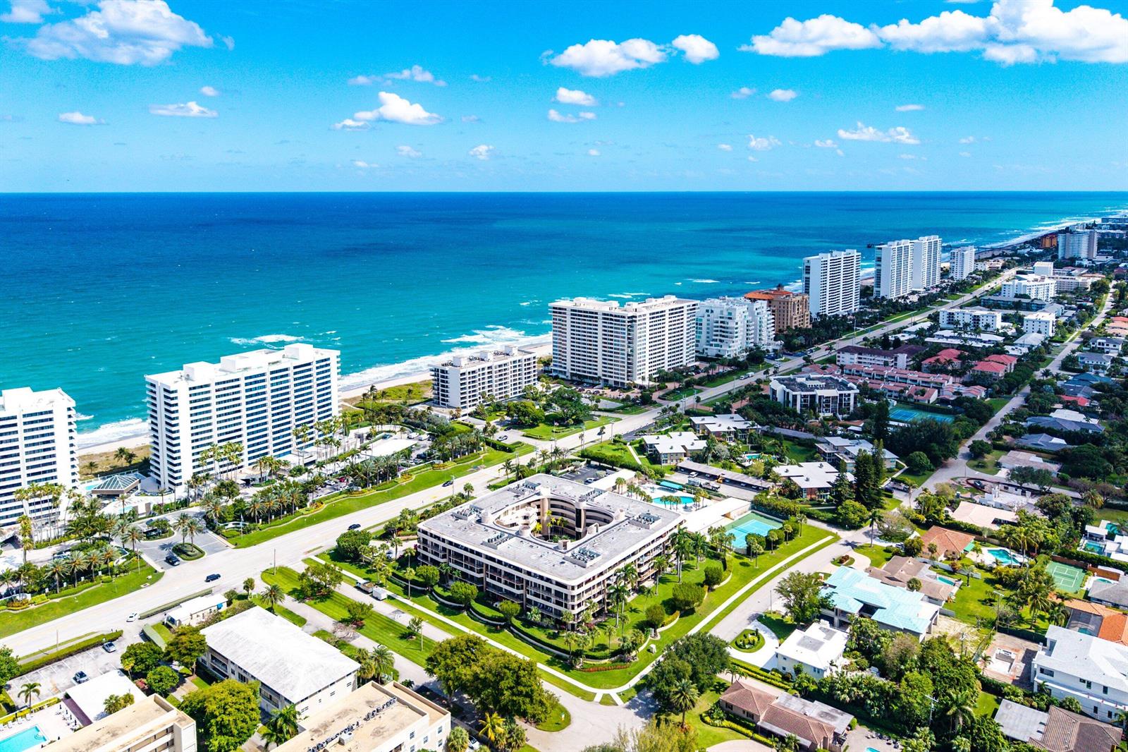 An aerial view shows high-rise apartment buildings along a sandy beach and the ocean — 1401 S Ocean Boulevard # 1050, Boca Raton FL 33432, BOCA RATON, FL