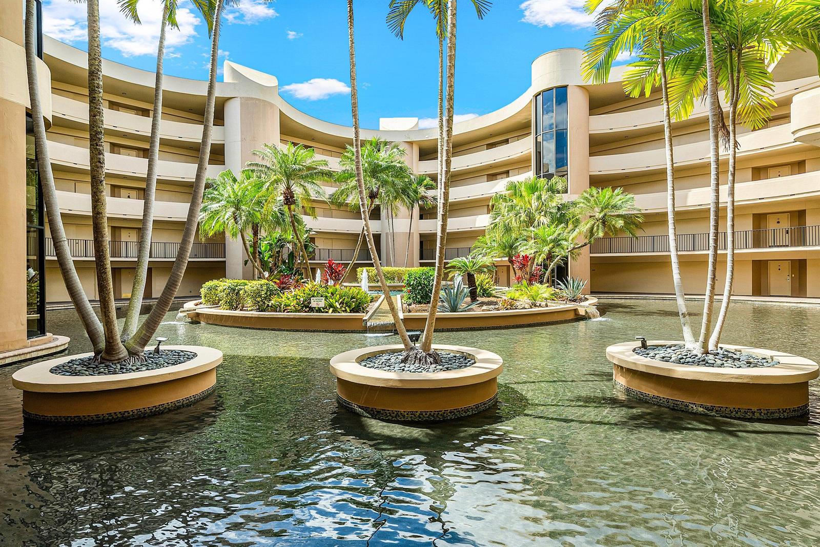 A circular courtyard features a central water feature with palm trees and multi-story balconies — 1401 S Ocean Boulevard # 1050, Boca Raton FL 33432, BOCA RATON, FL