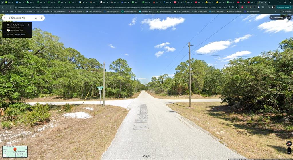 This is a street-level view of an intersection between two paved roads surrounded by trees — 3410 GOSSAMER AVENUE, LAKE PLACID, FL