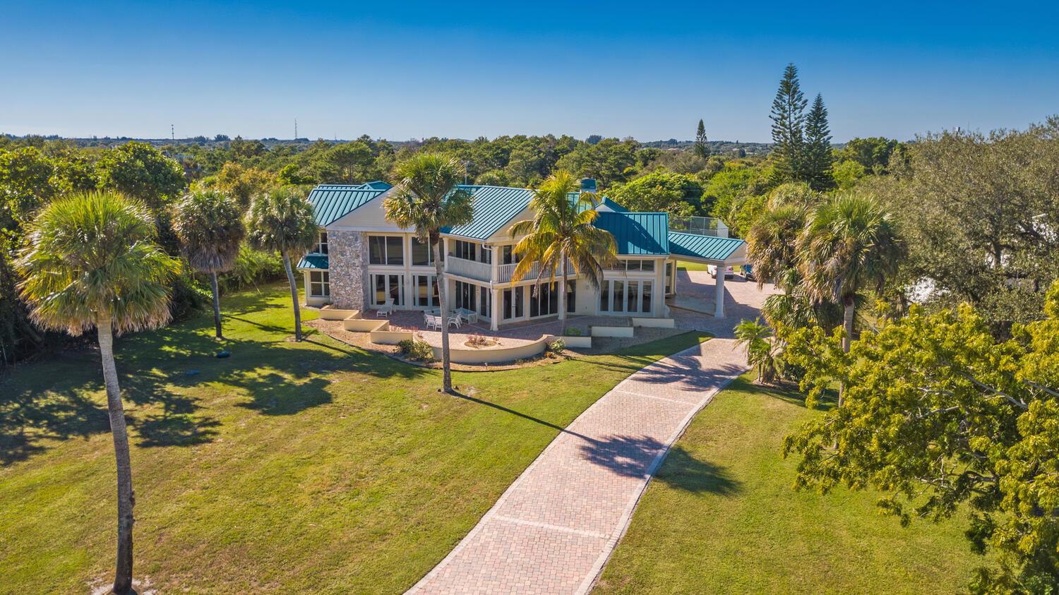 An aerial view of a two-story house with a metal roof and a brick driveway — 3343 S Indian River Drive, Fort Pierce FL 34982, FORT PIERCE, FL