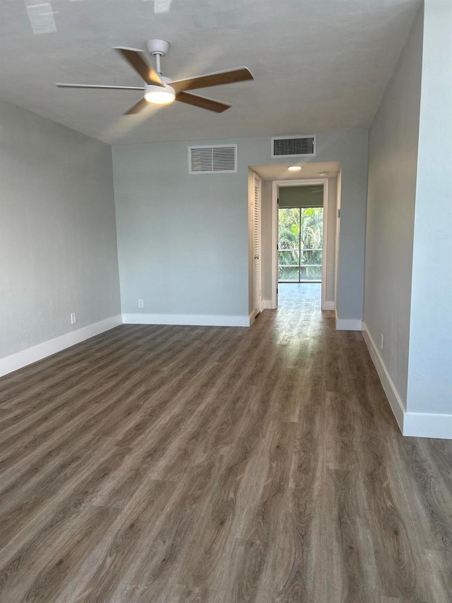 An empty room with light gray walls, wood-look flooring, a ceiling fan, and a balcony — 1980 Sunset Avenue # 12, FL 33461, FL
