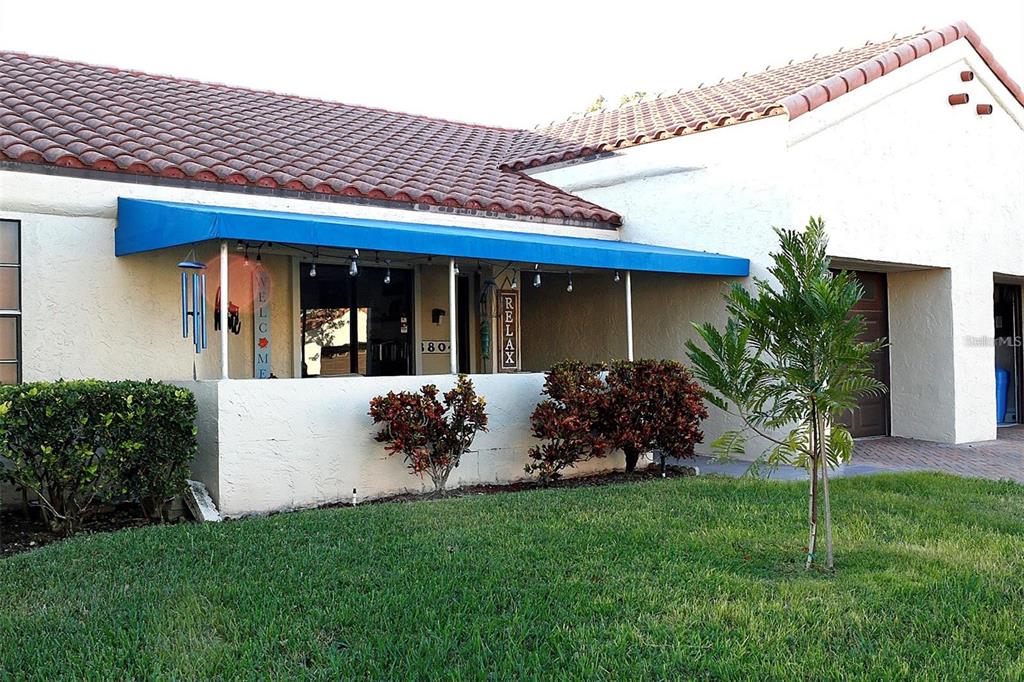 A single-story house with a red tile roof, blue awning, and a small front patio — 8804 40TH LANE N, PINELLAS PARK, FL