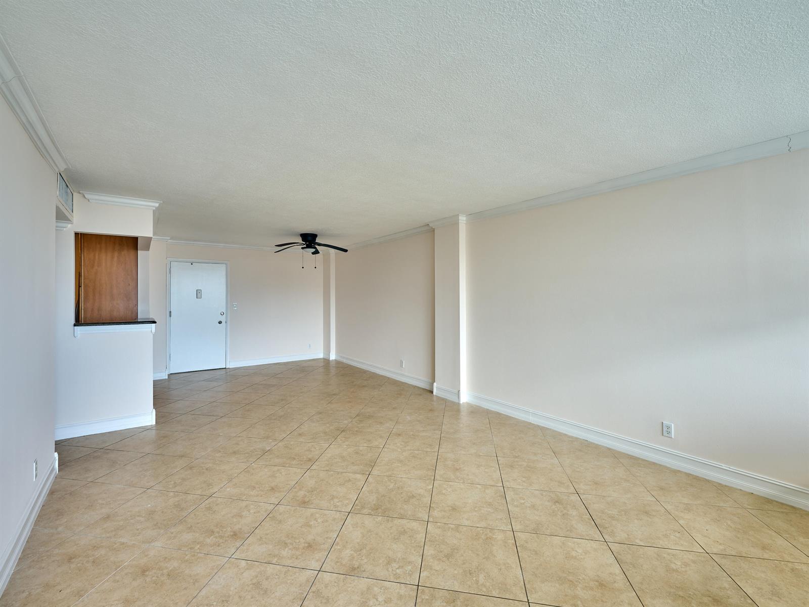 An empty living room features beige tile flooring, light-colored walls, and a ceiling fan — 305 N Pompano Beach Boulevard # 1204, Pompano Beach FL 33062, POMPANO BEACH, FL