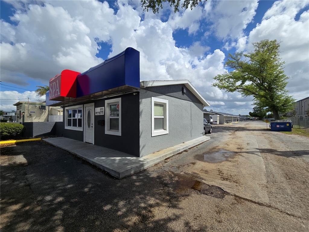 A small, gray commercial building with a red and blue awning sits on a lot — 11151 66TH STREET, LARGO, FL
