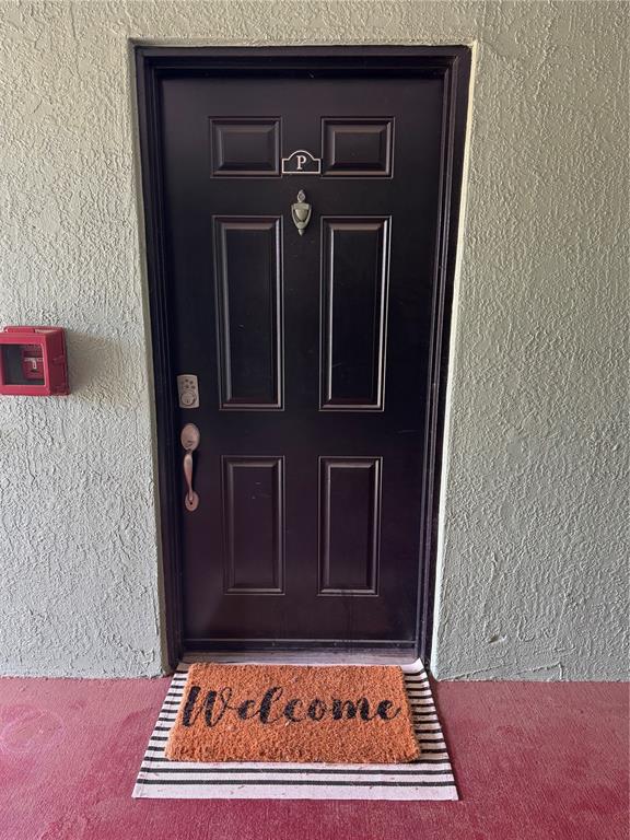 A dark brown front door with a door knocker and welcome mat on a porch — 2053 DIXIE BELLE DRIVE UNIT 2053P, ORLANDO, FL