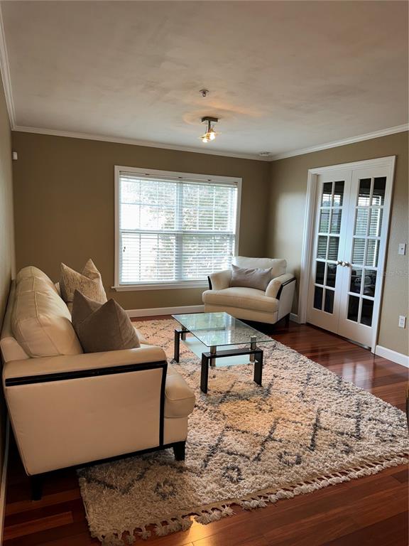 A living room features a white sofa, an armchair, a glass coffee table, and hardwood floors — 2053 DIXIE BELLE DRIVE UNIT 2053P, ORLANDO, FL