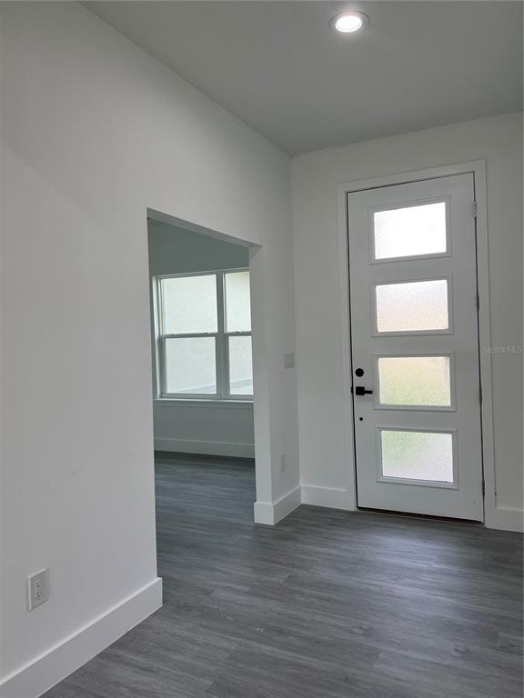 An entryway features a white door with four frosted glass panels and gray flooring — 200 FARLEY STREET SW, PALM BAY, FL
