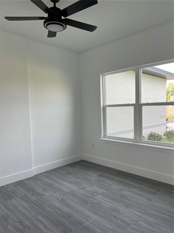 A bedroom with white walls, gray wood-look flooring, a ceiling fan, and a double window — 200 FARLEY STREET SW, PALM BAY, FL