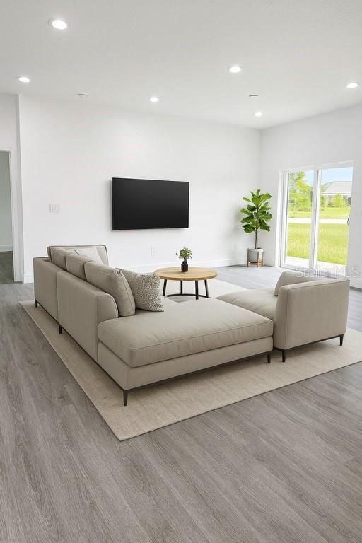 A modern living room features a beige sectional sofa, a round coffee table, and a television — 200 FARLEY STREET SW, PALM BAY, FL