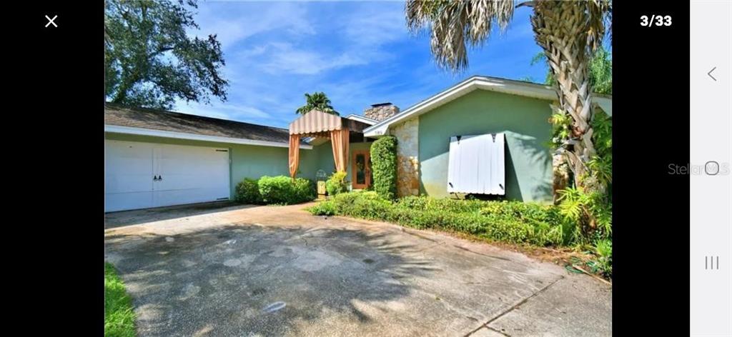 A single-story house with a white garage door, stone accents, and a covered entryway — 589 THORNBURG ROAD, BABSON PARK, FL
