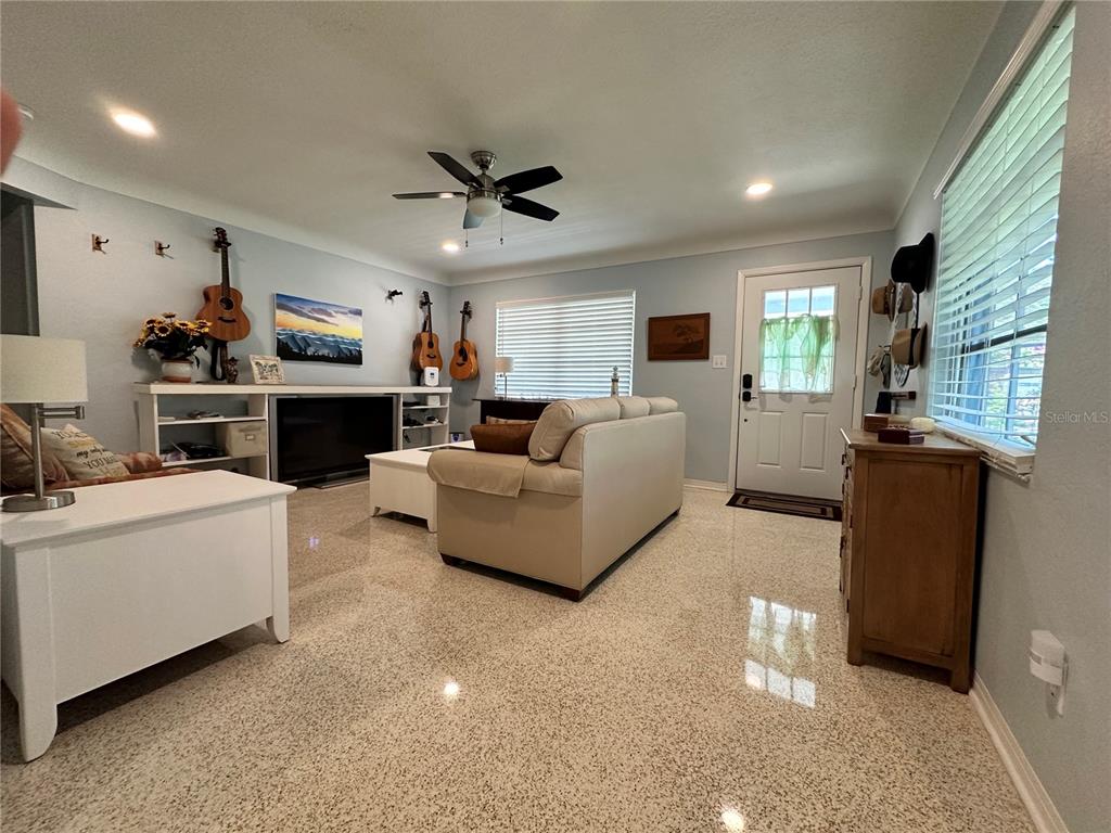 A living room features light blue walls, a beige sofa, and polished terrazzo flooring — 2831 CLINTON STREET S, GULFPORT, FL