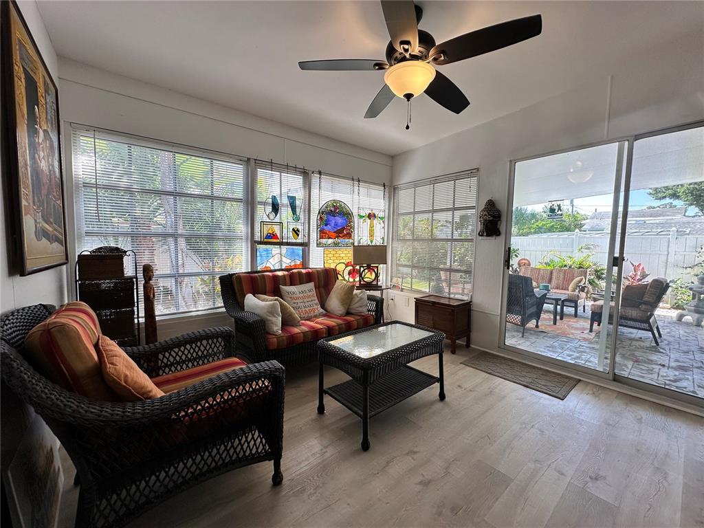 A sunroom with wicker furniture, a ceiling fan, and sliding glass doors leading to a patio — 2831 CLINTON STREET S, GULFPORT, FL